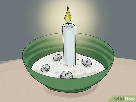 Шаг 3 Смажьте и зажгите свечу, прежде чем поместить ее в чашу.
